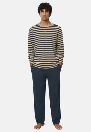 Langärmliges gestreiftes Shirt in Creme und Marine, kombiniert mit marinen Hosen. Das Shirt hat einen runden Ausschnitt und eine lockere Passform.