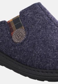 Marineblauer Filzschuh zum Hineinschlüpfen mit schwarzer Gummisohle, ausgestattet mit einer strukturierten Oberfläche und einem karirten Stoffakzent an der Seite mit einem runden Logo.