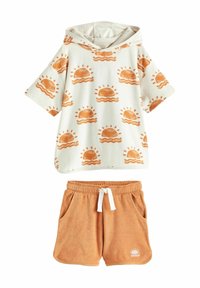 Hættetrøje i hvid med orange solmønstre, parret med orange frottéshorts med en hvid snøre og sollogo.