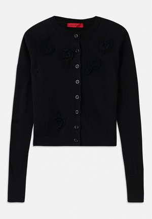 Svart kort cardigan med lange ermer, som har rund hals, svarte blomster-applikasjoner og knappelukking. Glatt tekstur, ribbestrikkede mansjetter.