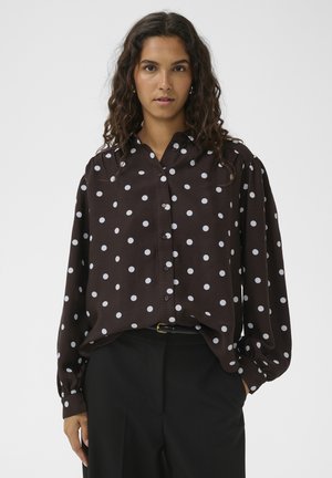 Braunes, langärmeliges Hemd mit Knopfleiste und weicher Textur. Es ist mit weißen Punkten unterschiedlicher Größe für Kontrast versehen.