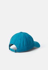 Teal blue cotton baseball cap with adjustable metal strap, visible from the back on a plain white background.