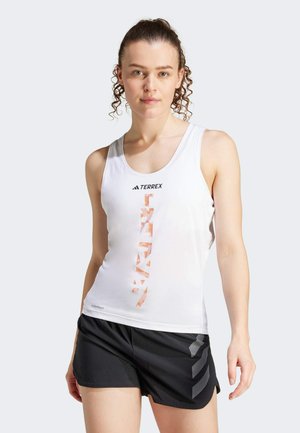Canotta atletica bianca con motivo geometrico arancione e grigio e logo, abbinata a pantaloni corti neri con design a strisce laterali.
