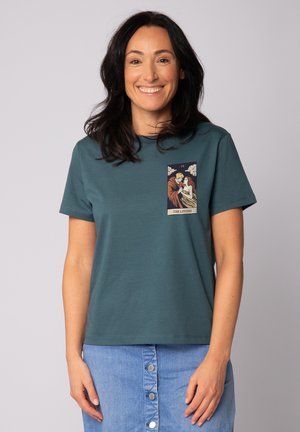 Teal katoenen t-shirt met korte mouwen en een ronde hals. Voorzien van een grafische patch met het label "De geliefden" en een ingewikkelde illustratie.