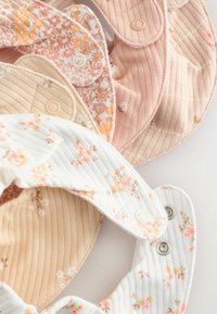 Set van geribbelde en met bloemenpatroon bedekte slabbetjes in beige, roze en witte tinten, voorzien van drukknoopsluitingen en een zachte katoenen textuur.