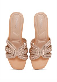 Las sandalias deslizables de color rosa dorado presentan tiras trenzadas con acentos metálicos, una plantilla suave de color beige y un diseño de tacón bajo.
