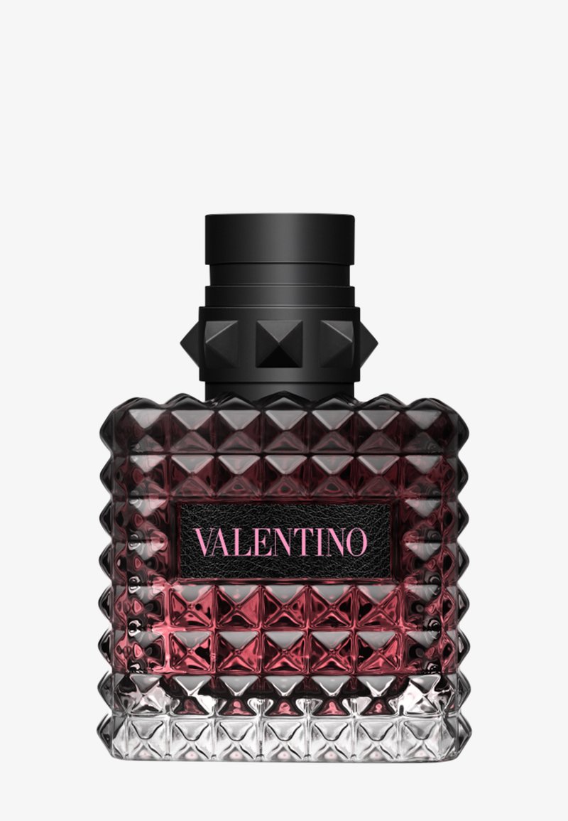 Donkerrode en heldere gefacetteerde glazen parfumfles met zwarte gestekelde dop en Valentino-label in roze letters aan de voorkant.