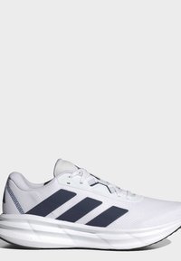 White athletic sneaker with three black stripes on the side and cushioned sole labeled "Cloudfoam" on a plain light background.