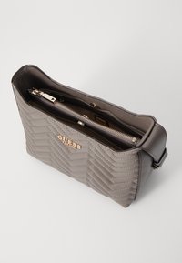 Quilted gray handbag with a zippered closure and gold-tone hardware; features an adjustable strap and interior pockets for organization.