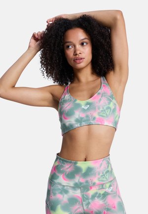 Sportowy biustonosz typu bralette w zielonym kolorze z kwiatowym różowo-żółtym wzorem. Wykonany z gładkiej tkaniny z szerokim pasem, zdobiony logo na środku przodu.