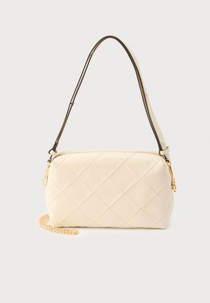 Cremefarbene, gesteppte Schultertasche mit einem geschwungenen schwarzen Riemen und goldenen Kettendetails vor hellem Hintergrund.