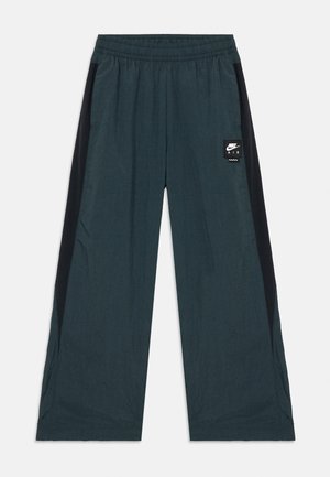 Pantaloni de trening de culoare teal închis cu panouri laterale negre, talie elastică, croi lejer și un mic logo Nike Air pe față.