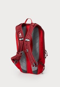 Red backpack with mesh interior, padded back support, adjustable straps, reflective accents, and multiple compartments for storage.