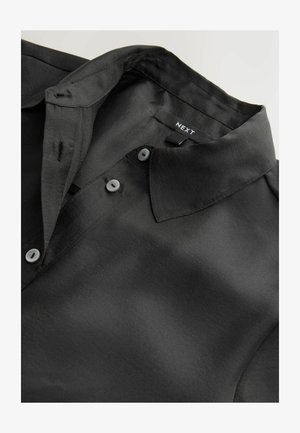 Czarna koszula z kołnierzykiem, wykonana z gładkiego materiału o subtelnym połysku. Posiada zapięcie na guziki oraz metkę oznaczoną "NEXT."