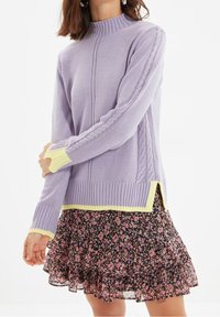 Maglione reversibile viola chiaro con scollatura e polsini a coste, caratterizzato da dettagli a trecce e un accento giallo sull'orlo e sui polsini.