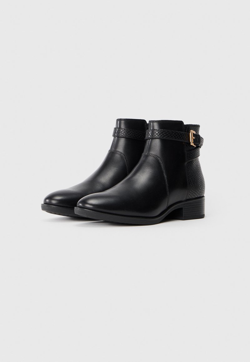 Bottines en cuir noir avec un talon texturé, une sangle tressée et un détail en boucle dorée. Surface lisse et design à bout rond.
