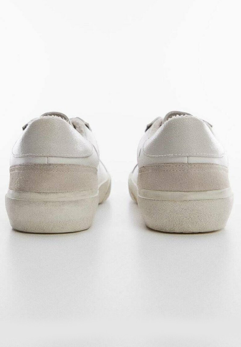 Weiße Leder-Sneaker mit einem strukturierten Wildlederpanel an der Ferse. Runde Form, Gummisohle, minimalistisches Design und angenähte Akzente.