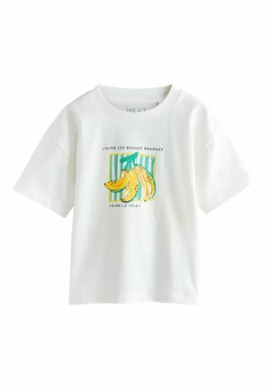 White short-sleeve t-shirt with a bananas graphic and French text "J'aime les bonnes bananes, J'aime le soleil" on a green striped background.