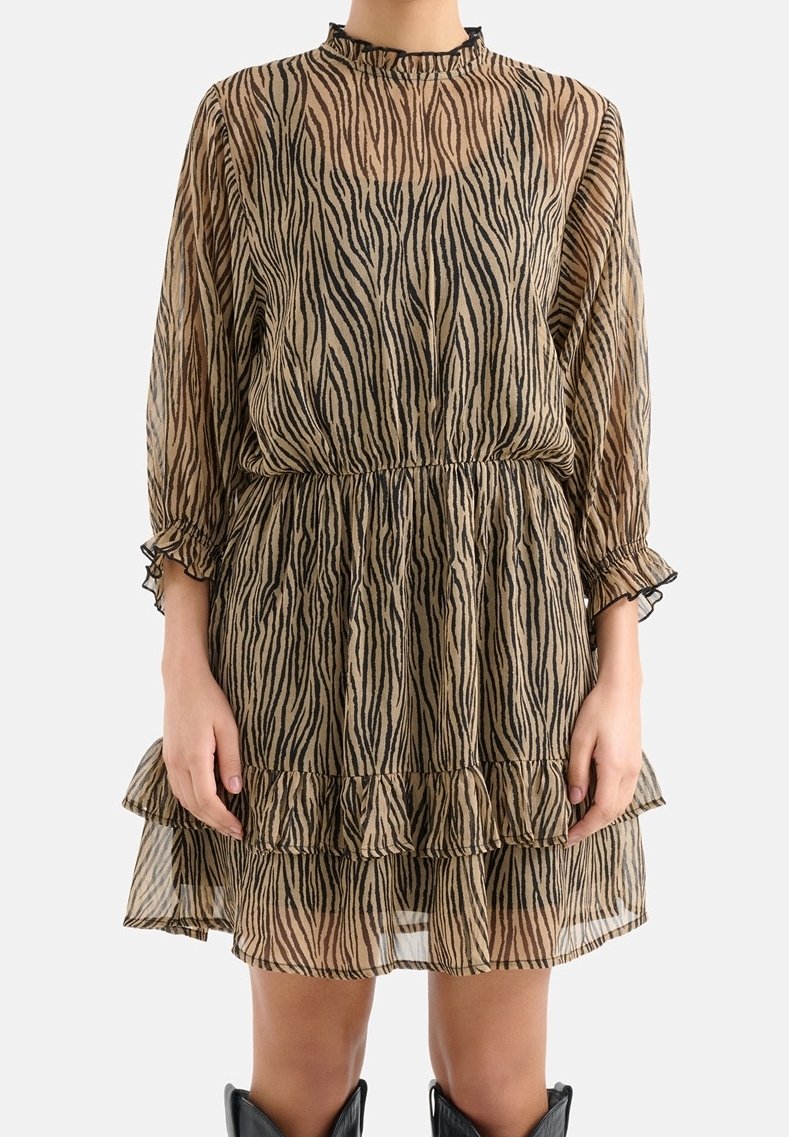 Durchsichtiges, zebra-gestreiftes Kleid in Beige und Schwarz, mit einem Rüsche-Saum, langen Ärmeln und einem hohen Kragen mit einem rüschenden Rand.
