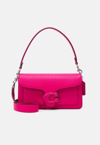 Pink leather handbag with a textured finish, featuring a flap closure and a prominent letter 'C' hardware accent. Adjustable strap included.