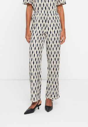 Mønstrede vide bukser i creme med blå langstrakte ovale motiver; letvægtsstof, elastisk talje, parret med sorte slingback hæle.