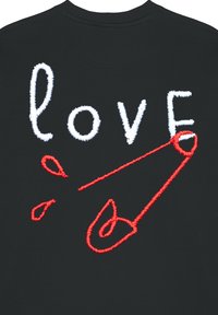 Un tessuto nero mette in mostra un testo ricamato bianco con la parola "love" e un design di spillo di sicurezza rosso, caratterizzato da linee audaci e forme distintive.