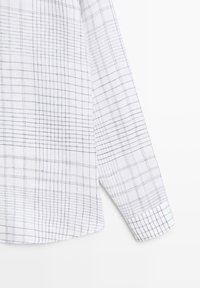 White long-sleeve shirt sleeve with thin black intersecting grid lines forming a checkered pattern.