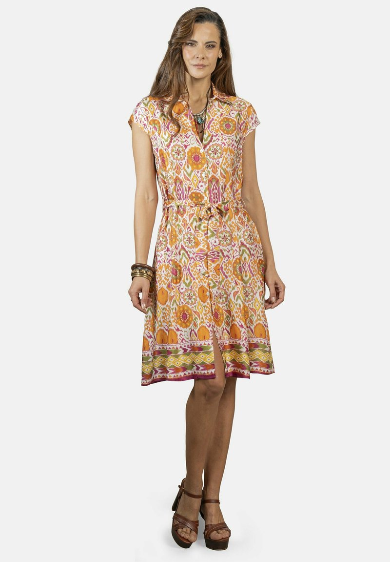 Vestido de flores colorido con mangas cortas, cintura ceñida y falda hasta la rodilla. Presenta un cierre frontal con botones y un dobladillo decorativo.