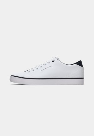 Bijeli niskoprofilni tenisice s crnim detaljem na peti, bijelim vezicama i crnom prugom na potplatu, oznakom Tommy Hilfiger logotipom na strani.