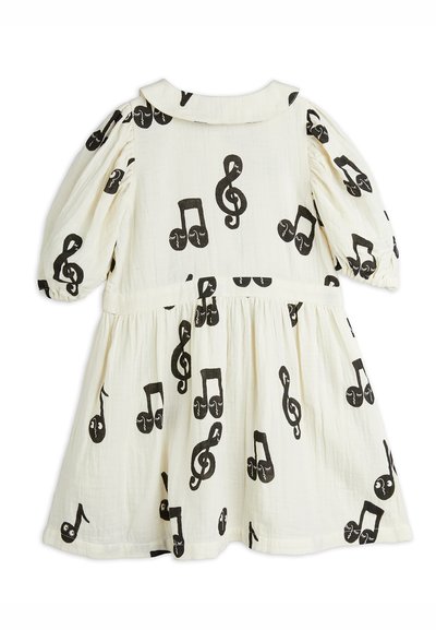 White dress with black musical note print. Features puff sleeves, a rounded collar, and a gathered waistline for a flared silhouette.