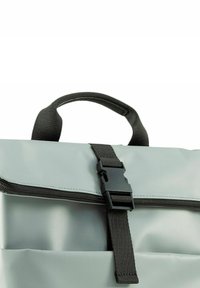 Borsa impermeabile grigia chiara con zip e tracolla nera. Presenta una maniglia robusta e una chiusura con fibbia in plastica. Texture liscia.