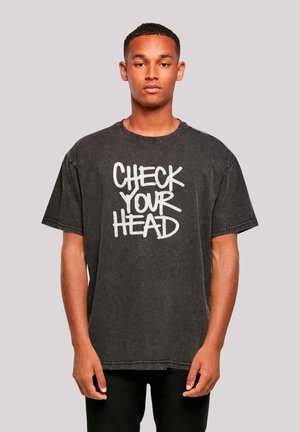 Black cotton t-shirt featuring a graphic print with the text "CHECK YOUR HEAD" in white, short sleeves, and a relaxed fit.