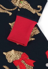 La tela con estampado de leopardo presenta gatos beige con lazos rojos sobre un fondo marino. Los puños rojos están hechos de un tejido acanalado elástico.