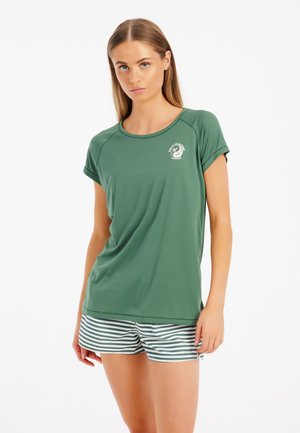 Top verde a maniche corte con scollatura rotonda, caratterizzato da un logo circolare. Abbinato a pantaloni corti a righe nei toni del bianco e del verde.