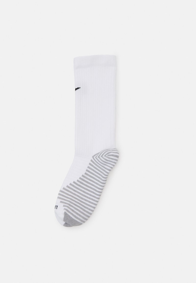 Chaussette de sport blanche avec texture côtelée, un logo noir et un talon gris avec un design rayé en bas.