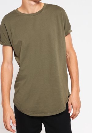 T-shirt vert olive à manches courtes en coton doux. Encolure ronde, ourlet arrondi, manches retroussées et coupe décontractée.