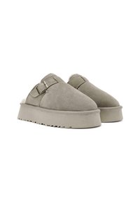 Zachte suède instap schoenen in lichtgrijs met een dikke platformzool en een verstelbare gesp. Voering van zacht, fluffy materiaal voor warmte en comfort.