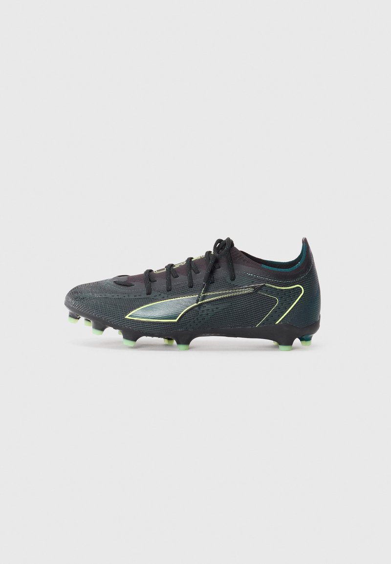 Black soccer cleat with textured upper, green highlights, and a streamlined design. Features a lace-up closure and molded studs for traction.