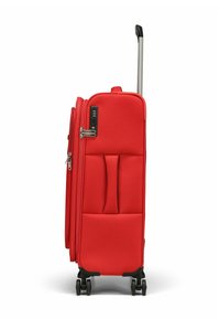 Valise souple rouge avec un design vertical, des zippers, un cadenas à combinaison et quatre roues pour une maniabilité facile.