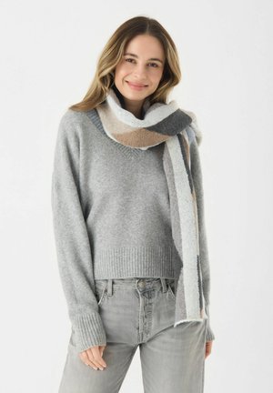 Pull en tricot gris clair avec un ourlet et des poignets côtelés, associé à une écharpe rayée multicolore dans des teintes beige, gris et blanc cassé.