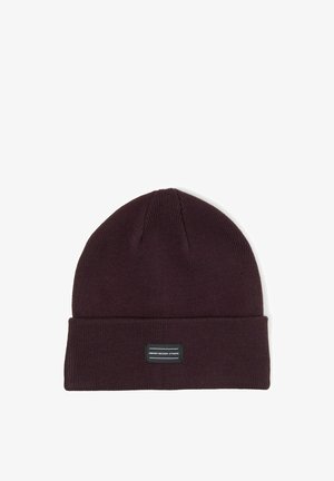 Gorro de punto marrón oscuro con puño doblado y pequeña etiqueta rectangular negra centrada en la parte frontal.