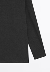 Donkergrijs shirt met lange mouwen, getoond van middel tot mouw tegen een witte achtergrond, met een eenvoudige, gladde stoftextuur zichtbaar.