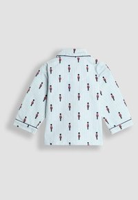 Modrá pruhovaná pyžamová košeľa s dlhými rukávmi, ktorá má opakovaný vzor hračkárskych vojakov. Námornicky modré obšitie okolo goliera a manžiet.