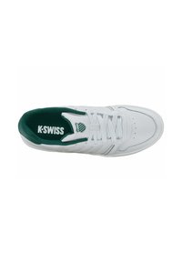 Sneaker athletic alb cu captuseala interioara verde, brâu din piele texturată și sistem de șireturi. Dispune de logo-ul K-Swiss și trei dungi pe lateral.