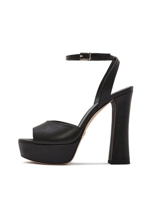 Czarna skórzana sandałka na platformie na wysokim obcasie z paskiem wokół kostki i srebrną klamrą, z grubym słupkowym obcasem oraz otwartym noskiem.