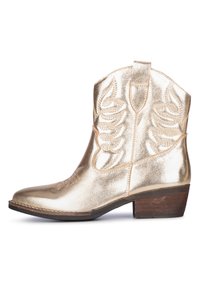 Zlatá kovbojská bota s lesklou kovovou texturou, zakřivenou špičkou, ozdobným šitím a krátkým podpatkem. Má boční poutka pro snadné nazouvání.