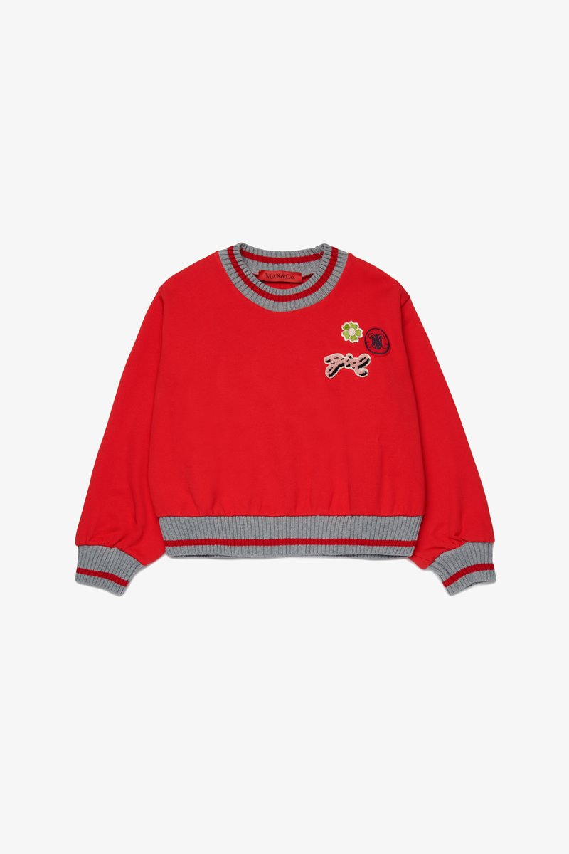 Felpa rossa con colletto e polsini a coste grigi, caratterizzata da toppe ricamate tra cui un fiore e dettagli testuali. Materiale in morbido cotone.