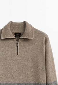 Brown zippered sweater with a ribbed collar, featuring a textured knit pattern and a contrasting gray stripe at the hem.
