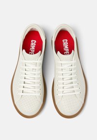 Weiße perforierte Sneaker mit flachen Schnürsenkeln, einer Gummisohle und roten Einlegesohlen mit dem "CAMPER"-Logo. Minimalistisches Design mit klaren Linien.