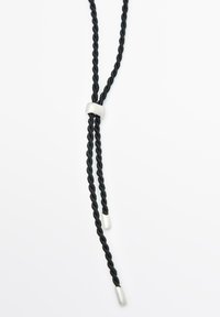 Collana in corda nera intrecciata con chiusura metallica argentata e due estremità affusolate. Presenta una texture liscia e un design semplice.